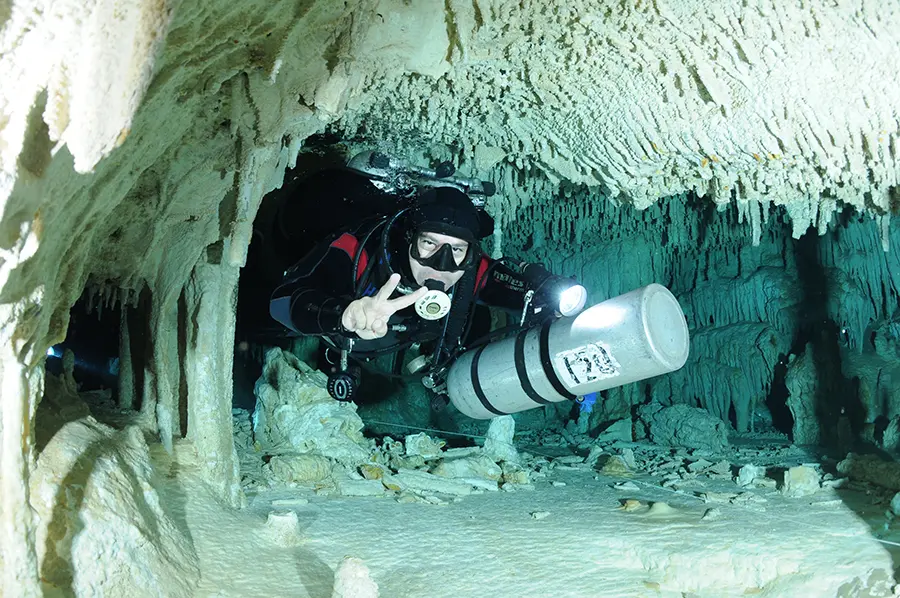 David Carrillo buceando en un pasaje subterráneo con espeleotemas.