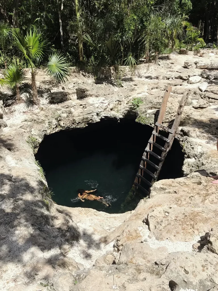 Cenote of the Mexican Caribbean in opening of the floor with girl swimming